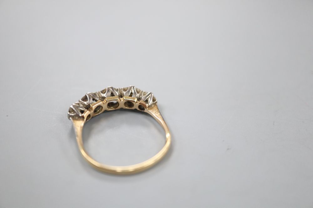 An early 20th century yellow metal and graduated five stone old cut diamond ring, size R, gross 3 grams.